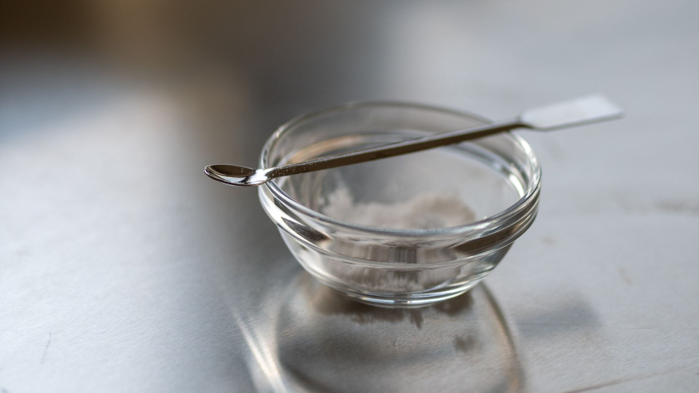 Close up van ene potje met wit poeder en een spateltje