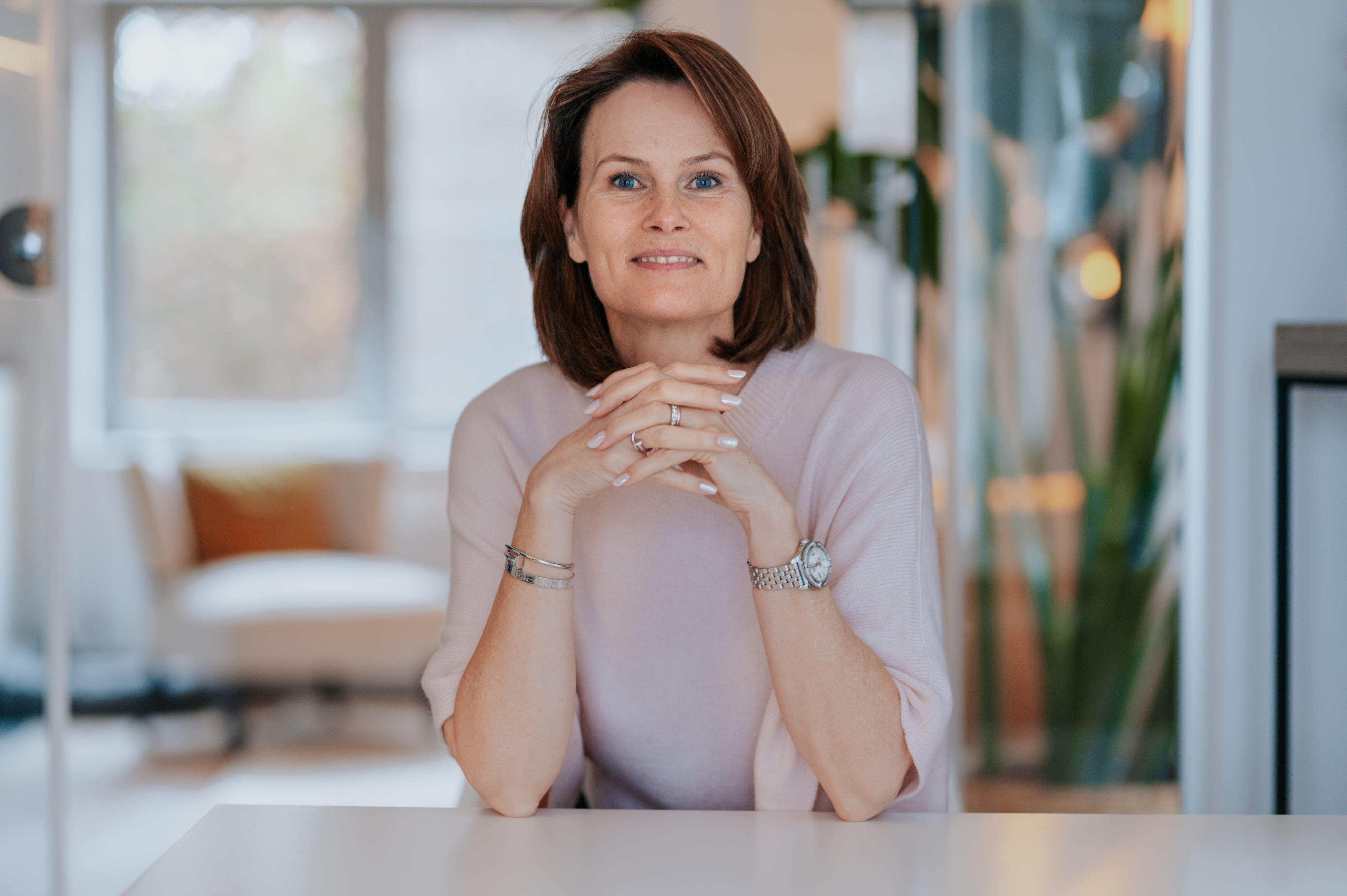 Sofie kijkt in de lens, zittend aan haar buro